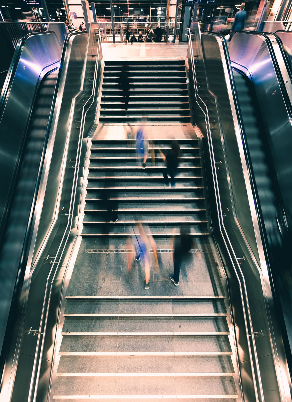 Commuters in motion on the stairs of a modern transit hub